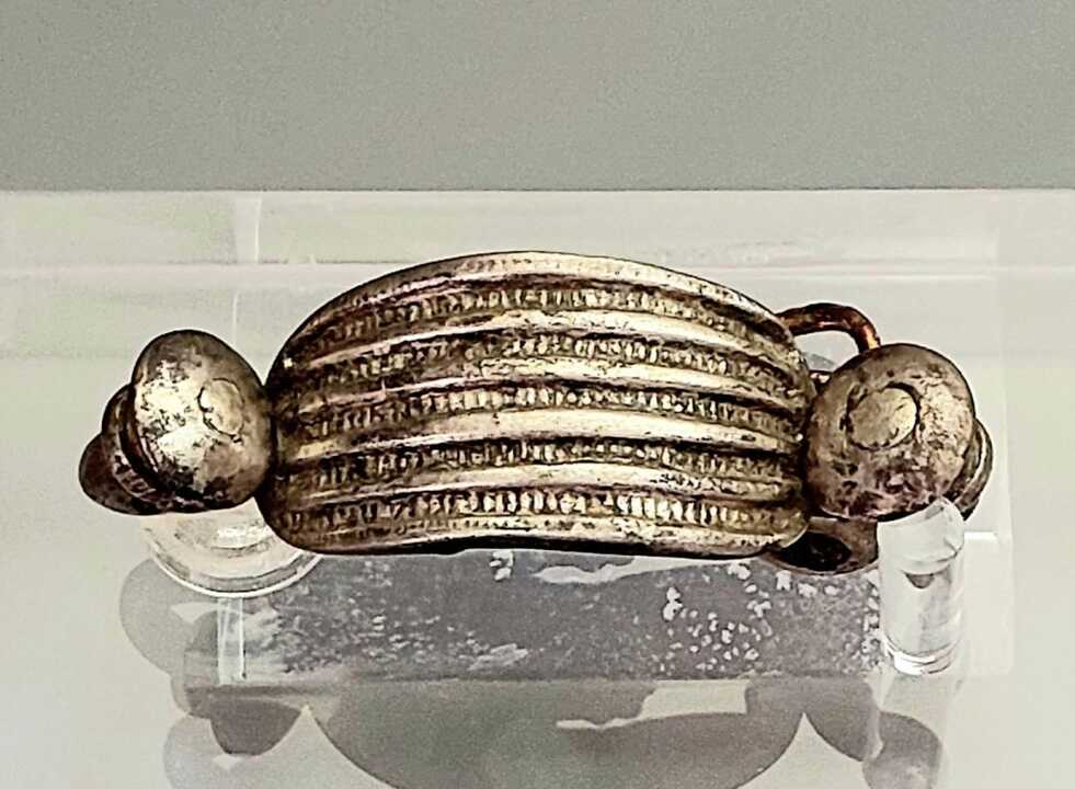 Es una pieza de gran belleza y magnífica conservación, de 4,9 centímetros de longitud, decorada con acanaladuras lisas y rayadas.